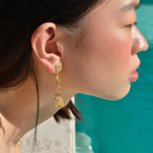 Pendientes largos Salvatore Organic con peridotos y turmalinas puestos en la oreja