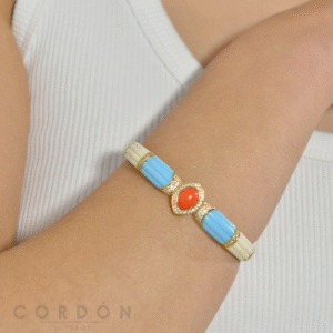 Brazalete rígido de latón dorado Salvatore Petra con esmalte y turquesa puesto en la muñeca