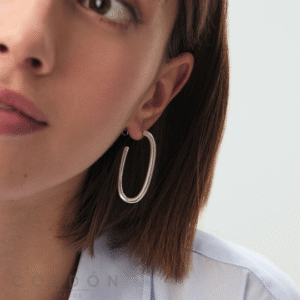 Pendientes Aro Chain ovalados plateados de Agatha París puestos en la oreja