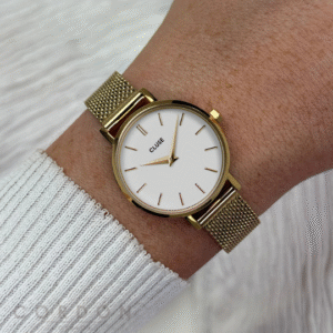 Reloj Cluse de mujer redondo dorado con malla puesto en la muñeca
